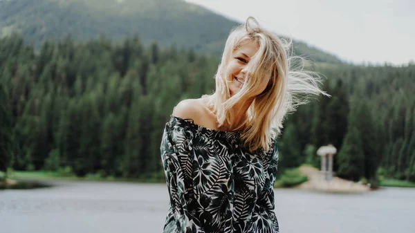 Usměvavá žena proti horské krajině a jezeru — Stock fotografie