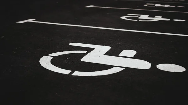 Parking place sign for disabled on dark brick