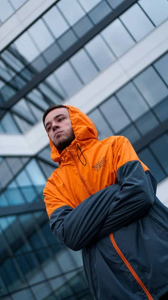 젊은 남자 에 오렌지 작업 유니폼 - 유리 건물 에 배경 — 스톡 사진