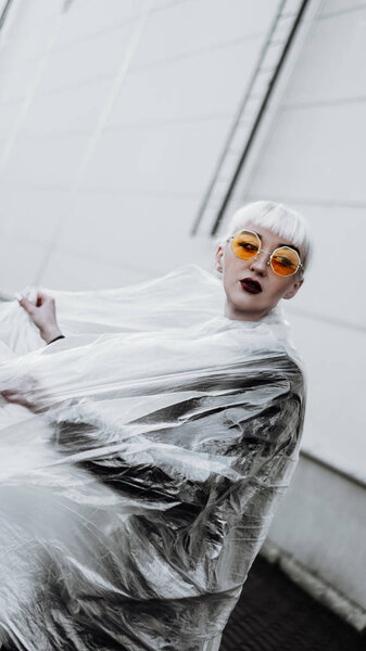 Ecology concept. Girl with plastic wrap. City Style.