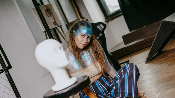 Artista bonita de cabelos compridos em oficina com manequins — Fotografia de Stock