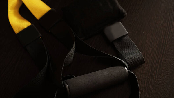 Вид крупным планом подвески на черном деревянном фоне тренировки дома - Фитнес дома
