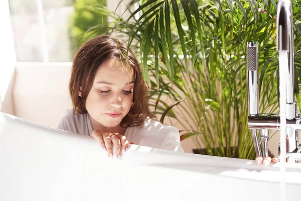 Think positive. Woman waits until the bathtub is filled with water — Stock Photo, Image