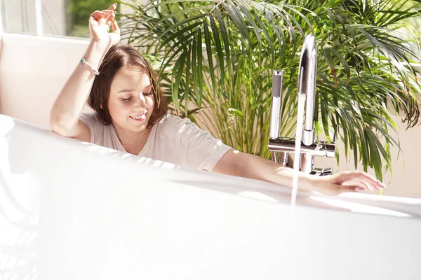 Denken Sie positiv. Frau wartet, bis die Badewanne mit Wasser gefüllt ist — Stockfoto