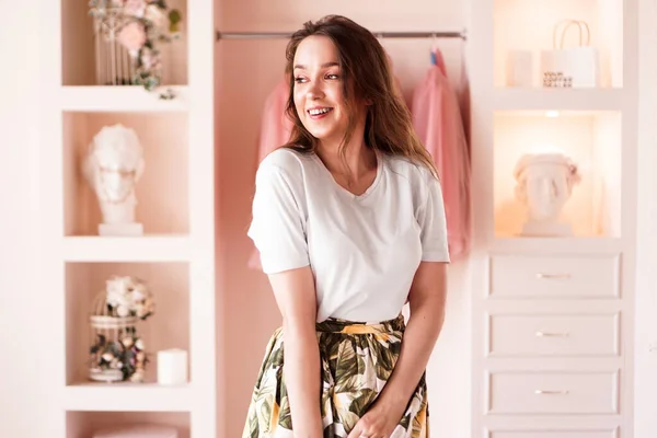 Happy young woman dressing up. Dressing room in pink