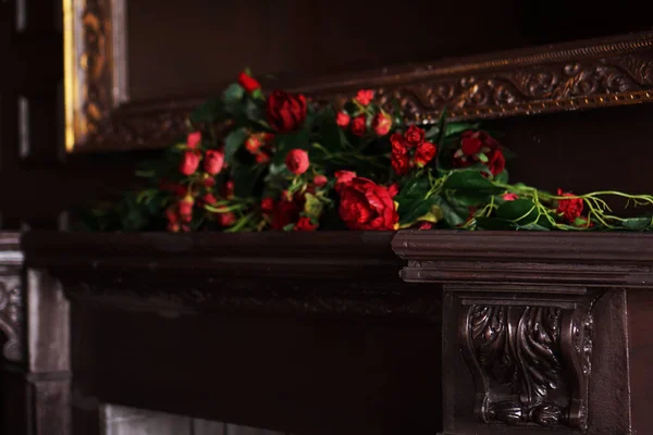 A fake flowers arrangement on a fireplace mantel