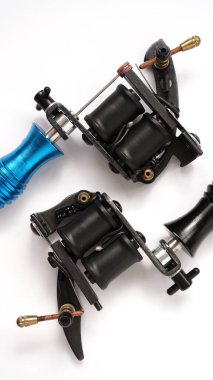 Beyaz arkaplanda iki dövme makinesi - dikey fotoğraf