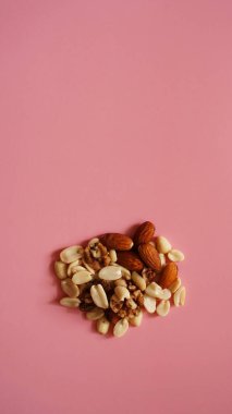 Parlak pembe arka planda bir avuç fındık, renk arkaplanı