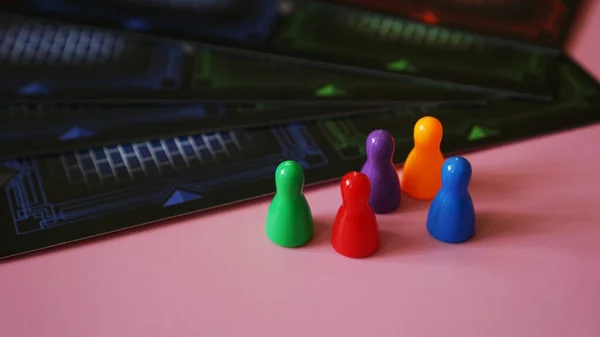 Figure di gioco da tavolo colorate su rosa — Foto Stock