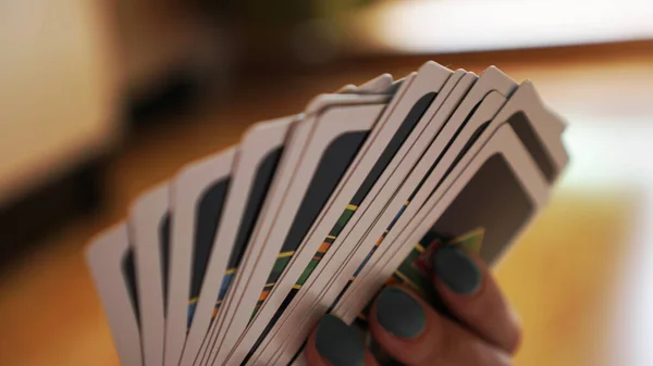 Gente jugando a las cartas. Mano con cartas sobre fondo borroso — Foto de Stock
