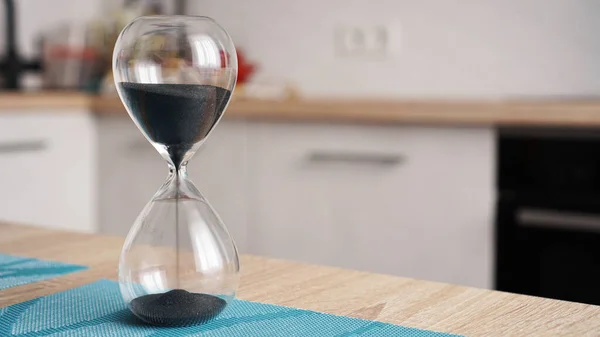 Primer plano de reloj de arena con cocina desenfoque en el fondo. Concepto de tiempo para cocinar — Foto de Stock