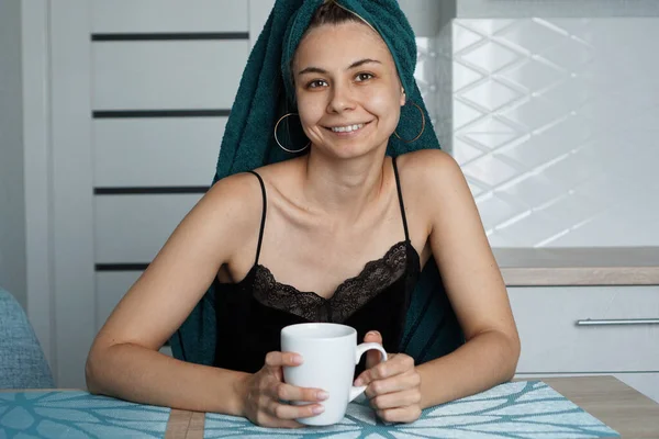 Menina bonita senta-se na cozinha com uma xícara de café. Relaxa. — Fotografia de Stock