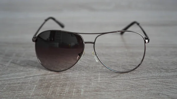 Lunettes de soleil cassées sur fond bois gris — Photo