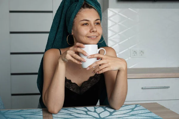 Mulher bonita senta-se na cozinha com xícara de café — Fotografia de Stock