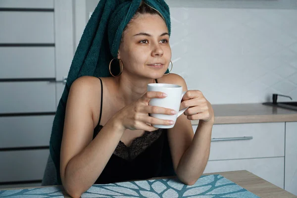 Mulher bonita senta-se na cozinha com xícara de café — Fotografia de Stock
