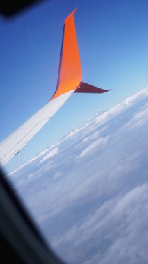 Mavi gökyüzü ve beyaz bulutlu uçak penceresinden bak