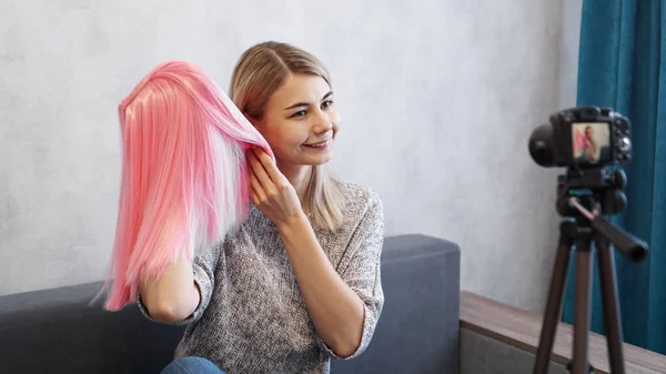 Una donna blogger registra video. Mostra parrucca rosa. Stilista e consulente di moda — Foto Stock