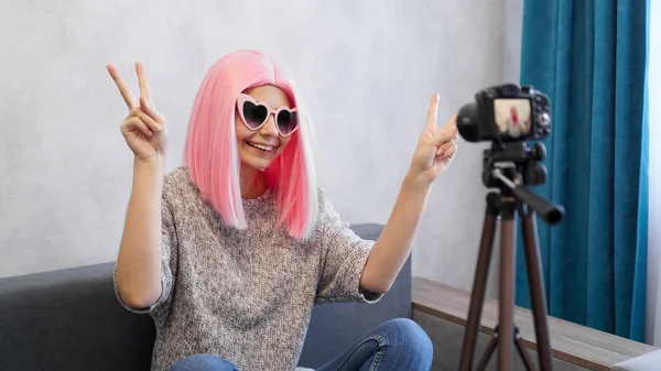 Felice teen girl blogger in parrucche rosa e occhiali. Mostra il segno della vittoria — Foto Stock