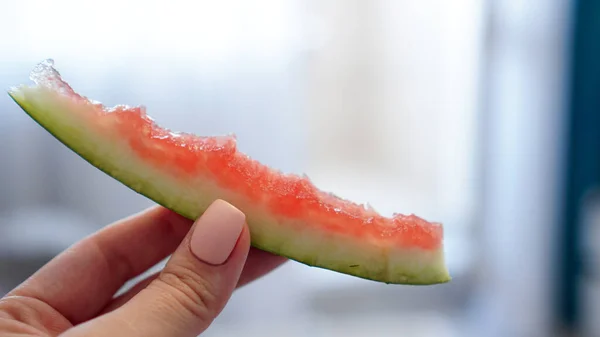 Hand hält gegessen Scheibe Wassermelone auf verschwommenem Hintergrund — Stockfoto