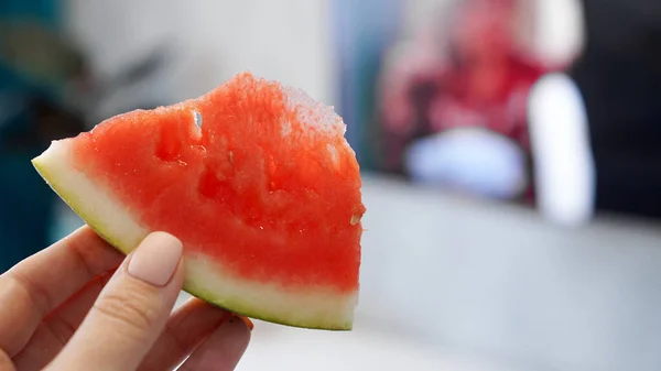Scheibe Wassermelone in der Hand auf verschwommenem Hintergrund — Stockfoto