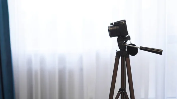 Uma câmara num tripé dentro de casa. Filmar um vídeo blog ou fotografar em casa — Fotografia de Stock