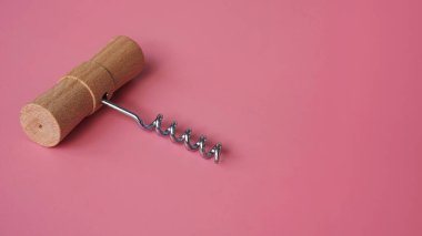 Pembe arka planda tahta el tirbuşonu.