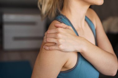 Spor salonundaki kadının omzunda ağrı var.