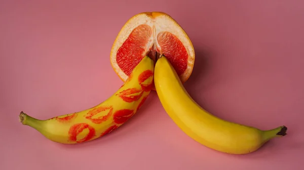 Två bananer och grapefrukt på en rosa bakgrund — Stockfoto