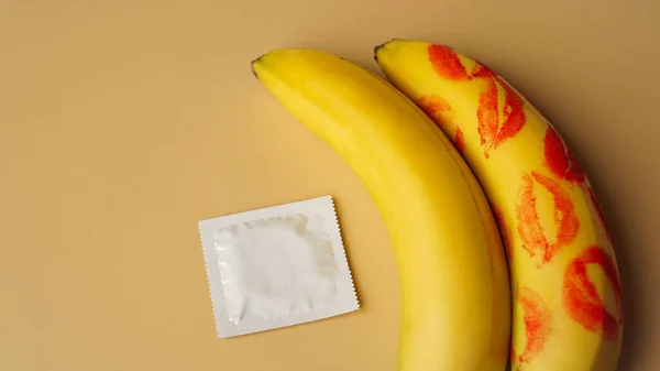 Kondomer och två bananer med spår av rött läppstift, begreppet preventivmedel — Stockfoto