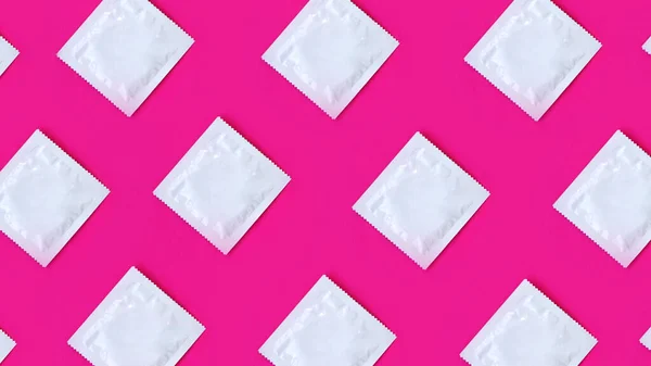 Molti preservativi in righe su sfondo rosa — Foto Stock