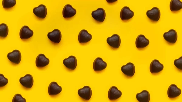 Czekolada w kształcie serca czekoladki na czerwonym tle z rzędu — Zdjęcie stockowe