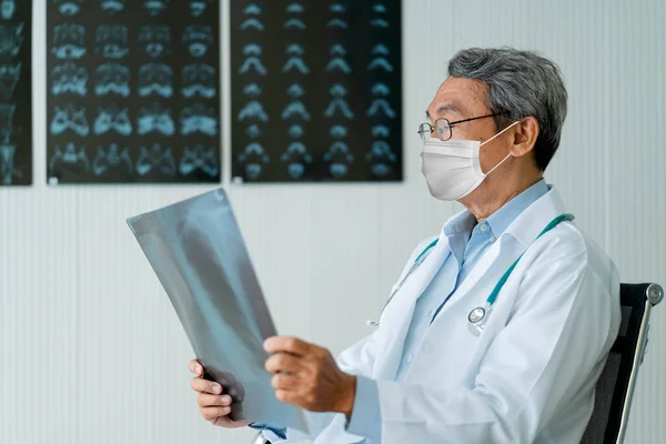 アジア系男性高齢者医師手によるX線フィルム解析診断胸部肺体の一部原因コロナウイルス感染白血球19拡散流行クリニック背景 — ストック写真