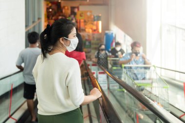 Covid salgından sonra yeni normal genç zeki Asyalı kadın süpermarkette yüz temizleme ya da maske korumalı yeni meyve sebzesi ve yeni normal yaşam tarzı seçiyor.