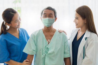 Bir grup doktor ve hemşire koruma maskesi takıyor. Enfeksiyonu kontrol ediyorlar ve tedavi ediyorlar. Klinik hastane geçmişinde covid-19 salgını var.