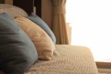 Modern kanepede duvar kağıdı kapağı arka plan tasarım konsepti olan bej renkli yumuşak yastıklar.