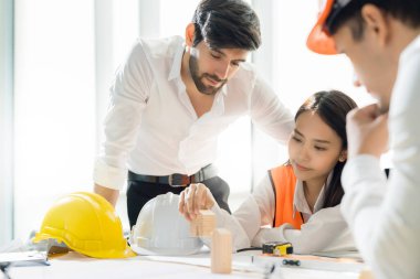 Asyalı ve Kafkasyalı genç yaratıcı mutlu gülüşler ve büyük başarı duygu takım çalışması danışman ve girişimci danışman beyin fırtınası ofis geçmişi.