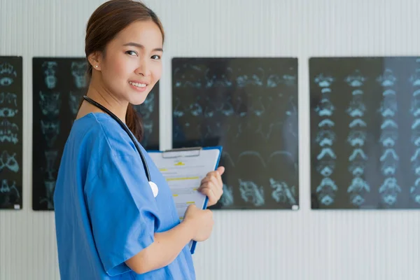 平和的自信に満ちたスマート魅力的なアジア女性医師笑顔で歓迎と陽気な手を持ちますチラシ検査患者でクリニック — ストック写真