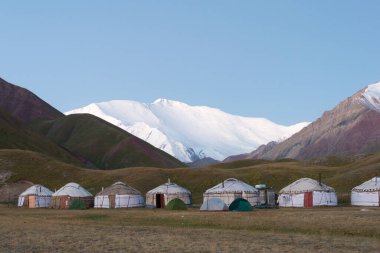 Osh, Kırgızistan - Kırgızistan 'ın Alay Vadisi' ndeki Tulpar Kol Gölü 'ndeki Turist Yurt Kampı' nda Lenin Tepesi 'nin Sabah Güneşi Manzarası (7134 metre). Kırgızistan 'daki Pamir Dağları.
