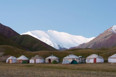 Osh, Kırgızistan - Kırgızistan 'ın Alay Vadisi' ndeki Tulpar Kol Gölü 'ndeki Turist Yurt Kampı' nda Lenin Tepesi 'nin Sabah Güneşi Manzarası (7134 metre). Kırgızistan 'daki Pamir Dağları.