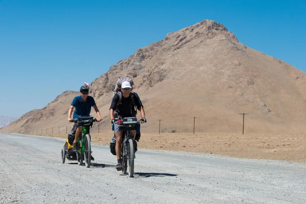Pamir Dağları, Kırgızistan - Gorno-Badakhshan, Tacikistan 'da Murghab' da Pamir Otoyolu üzerinde bisikletli bir adam.