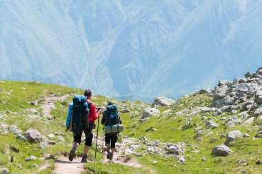 Kazbegi, Gürcistan - Gergeti Trinity Kilisesi 'nden Gergeti Buzulu' na yürüyüş parkurunda yürüyüş yapan bir grup dağcı. Kazbegi, Mtskheta-Mtianeti, Georgia 'da ünlü bir manzara..
