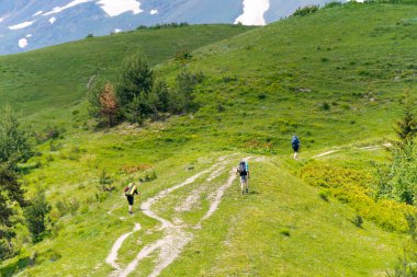 Mestia, Georgia - Mestia 'dan Koruldi göllerine giden yürüyüş parkurunda sırt çantalı turistler. Mestia, Samegrelo-Zemo Svaneti, Georgia 'da ünlü bir manzara..