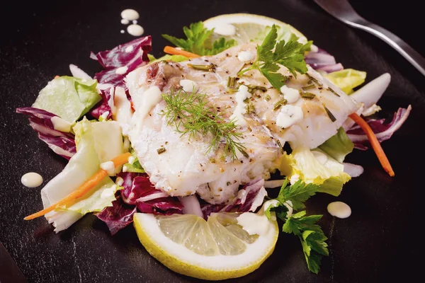 Filé de bacalhau grelhado com salada em placa de ardósia preta — Fotografia de Stock
