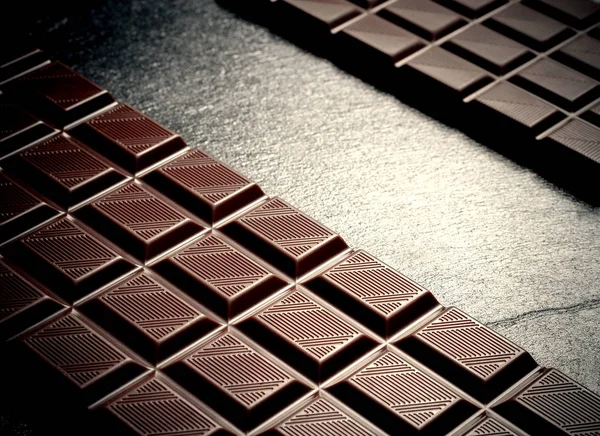 Schwarze Schokolade auf schwarzem Schieferteller — Stockfoto