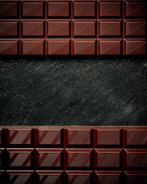 Black chocolate bar on black slate plate