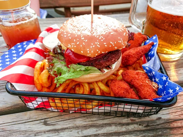 Hamburger with nuggets on twisted french fries — Stock Photo, Image