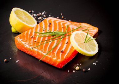 Siyah kayrak plaka üzerinde sulu somon fileto