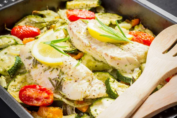 Kabeljauwfilet op paprika, UI met courgette en kaas — Stockfoto