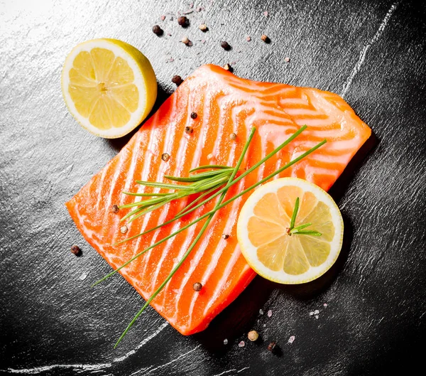 Juicy salmon fillet on black slate plate — Stock Photo, Image