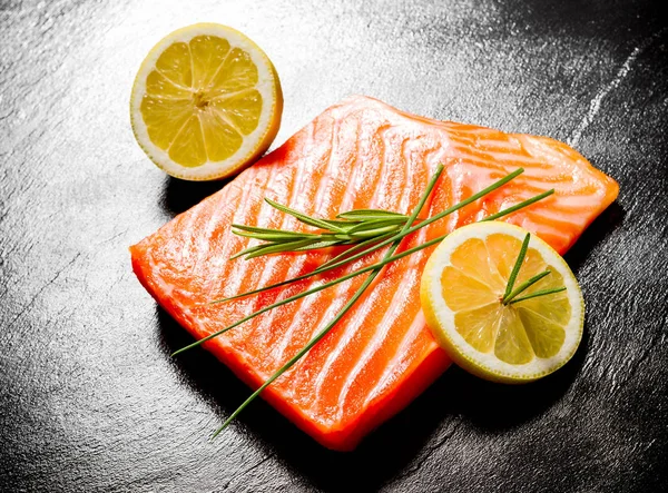 Juicy salmon fillet on black slate plate — Stock Photo, Image